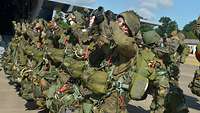 In einer Reihe stehend gehen die Fallschirmjäger in Gesten immer wieder ihre Tätigkeiten durch.