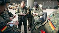 Mehrere Soldaten stehen im Halbkreis und machen sich Notizen