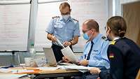 Three uniformed course participants discussing course contents
