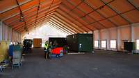 Soldaten vermessen in einem großen Bundeswehrzelt Stellflächen für Container.