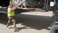 Ein Soldat hilft beim Beladen eines Flugzeuges