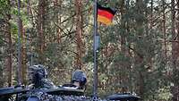 Kommandant und Ladeschütze schauen aus den Luken ihres Panzers