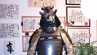 Ein Mann trägt eine traditionelle Panzerung der japanischen Samuraikrieger.