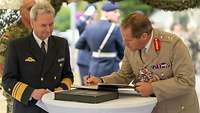 Vizeadmiral Daum und Lieutenant General Copinger- Symes unterschreiben im Gästebuch im ZOpKomBw