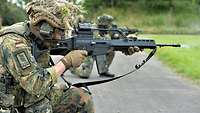 Drei Soldaten knien auf einer Schießbahn mit dem Gewehr im Anschlag.