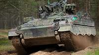 Ein Panzer des Typs Marder in voller Fahrt auf einem Waldweg