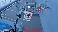 Ein kleines Schild mit der Aufschrift "Flugbetrieb" hängt in Mitten eines Durchgangs und versperrt diesen.