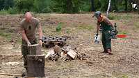 Zwei Soldaten zerkleinern Holz