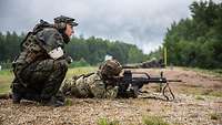 Ein Soldat liegt auf dem Boden und zielt mit seiner Waffe, ein zweiter Soldat hockt daneben