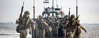 Amphibische Operationen 2 Mehrere deutsche Soldaten laufen mit Sturmgewehren von einem Landungsboot runter.