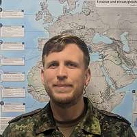 Ein Soldat lächelt in die Kamera.