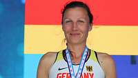Eine Frau bei einer Siegerehrung mit einer Goldmedaille um den Hals