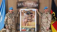 Zwei Soldaten mit blauem Barrett halten ein Plakat hoch