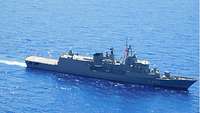 Ein graues Schiff fährt durch die ruhige See. Auf dem Rumpf stehen die Ziffern F-452. Die griechische Flagge ist gehisst.