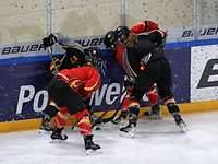 Training in Füssen Vier Eishockeyspielerinnen beugen sich eng über einen Puck und versuchen, ihn mit ihren Schlägern wegzuschießen