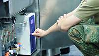 Ein Soldat bedient ein Gerät zur Sterilisation