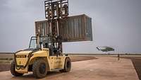 Ein Gabelstapler stellt einen 20 Fuß Container für den Transport mit dem CH-53 zur Verfügung