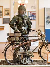 ein Wehrmachtssoldat mit seinem Fahrrad in einer Ausstellungshalle