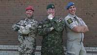 Internationale Zusammenarbeit Ein deutscher, ein österreichischer und ein kanadischer Soldaten stehen zusammen und posieren für ein Gruppenbild