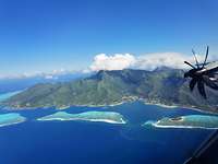 Tahiti von oben Aus dem Fenster des A400M ist ein Berg und Blaues Meer zu sehen