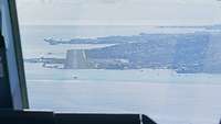 Aus dem Cockpit ist die Landebahn von Tahiti zu erkennen. Davor und dahinter das Meer