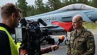 Major B steht vor einer Fernsehkamera und stellt sich den Fragen eines Redakteurs vom ZDF