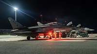 Techniker und Eurofighter auf dem Rollfeld mit Flutlicht