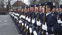 Angetretene Soldaten mit einem Gewehr vor der Brust