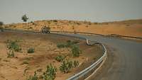 Kurvige aber befestigte Straße in Mali wird vom Konvoi befahren.