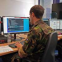 Soldat sitzt am Computer.