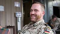Ein Soldat lacht in die Kamera