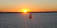 Foto Sonnenaufgang vor Bremerhaven Segelboot auf dem Meer im Sonnenaufgang