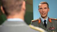 Brigadegeneral Dr. Freuding spricht mit einem Soldat während eines Interviews.