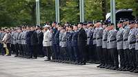 Eine angetretene Formation aus Soldatinnen, Soldaten und zivilen Angehörigen.