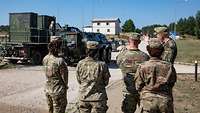 Soldaten schauen einen Panzer an