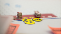 Spielsteine und Gefahrenzeichen liegen auf einer Spielkarte