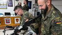 Zwei deutsche Soldaten zerlegen ein amerikanisches MG 