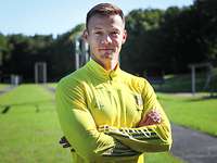 Ein Sportler lächelt in die Kamera.
