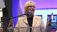 Die Verteidigunsgministerin steht vor einem Mikrofon und redet