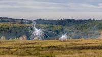 Signalmunition zieht zwei weiße Rauchfächer über einer Grasfläche. Rechts ein Schützenpanzer der slowakischen Armee.