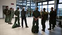 Servicemen and women stand in a circle for briefing