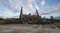 Zwei Panzer heben einen dritten Panzer mit ihren Kränen an