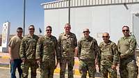 Eine Gruppe Soldaten steht vor einem Gebäude mit der jordanischen, der US-amerikanischen sowie der deutschen Flagge