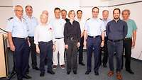 Zivile und militärische Frauen und Männer auf einem Gruppenbild.