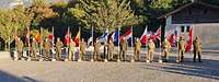 Die internationalen Delegationen stehen mit einer Landesflagge auf dem Platz vor dem Château de Valère in Sion