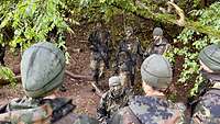 Soldaten stehen in einem Kreis in einem Wald.