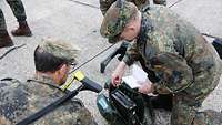 Zwei Soldaten beugen sich über ein Funkgerät