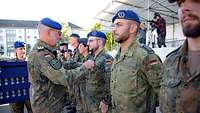 Medaillenverleihung durch den Inspekteur des Sanitätsdienstes Ein General verleiht einem Unteroffizier, der in einer Reihe mit vielen anderen Soldaten steht, eine Medaille