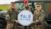 Ein Soldat überreicht einer Soldatin ein weißes Schild mit der Aufschrift Blue Bridge.