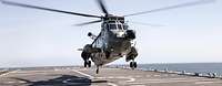 Ein Hubschrauber vom Typ Sea King landet auf dem Flugdeck eines Schiffes.